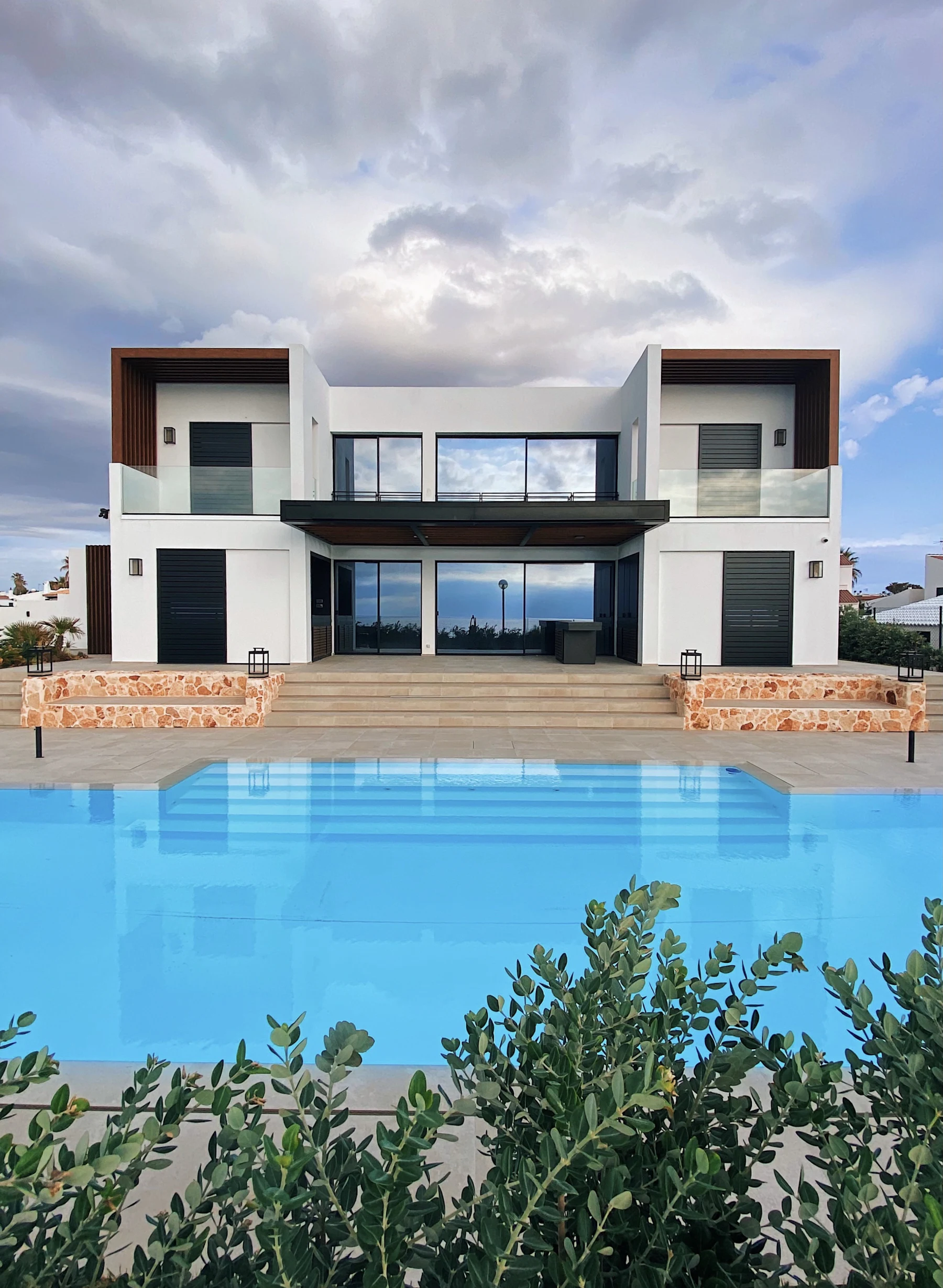 Two white villas above a swimming pool